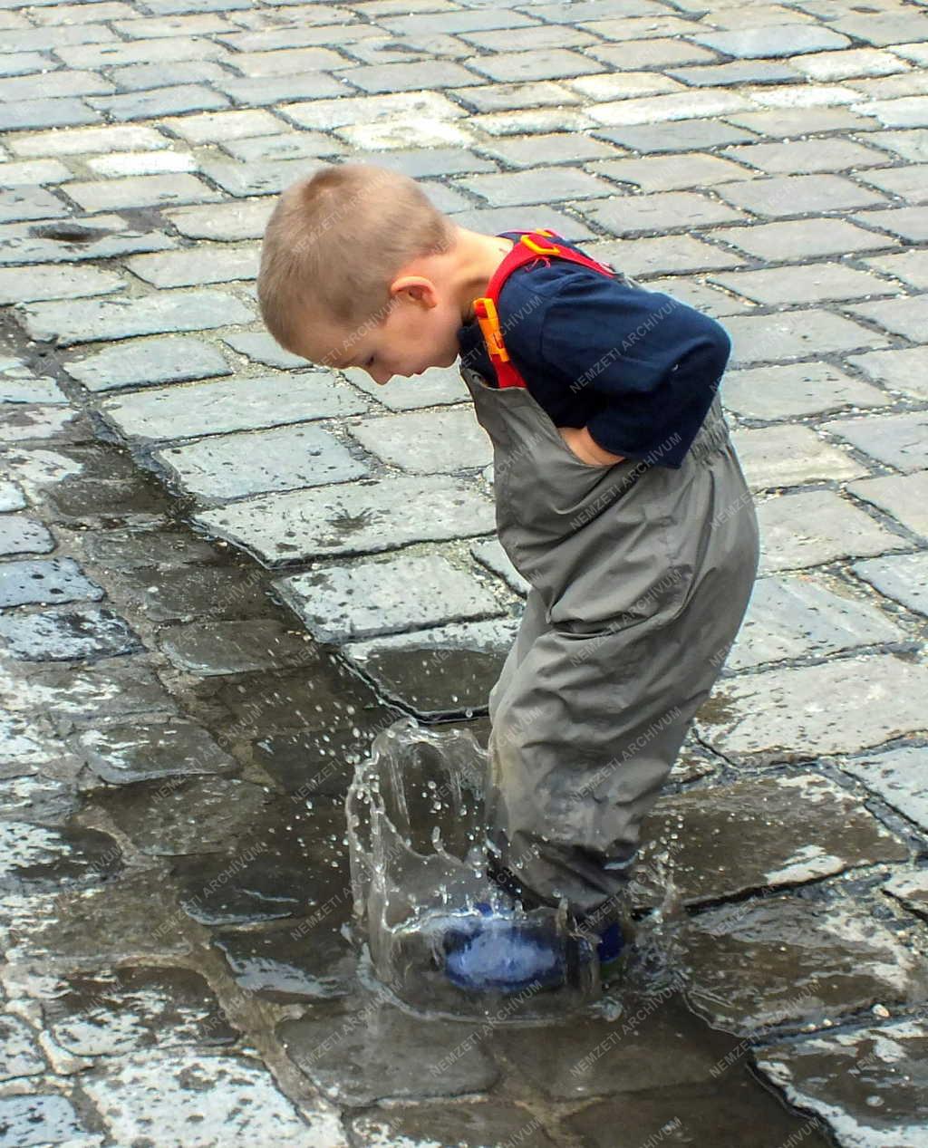 Életkép - Budapest - Pocsolyában játszó kisfiú