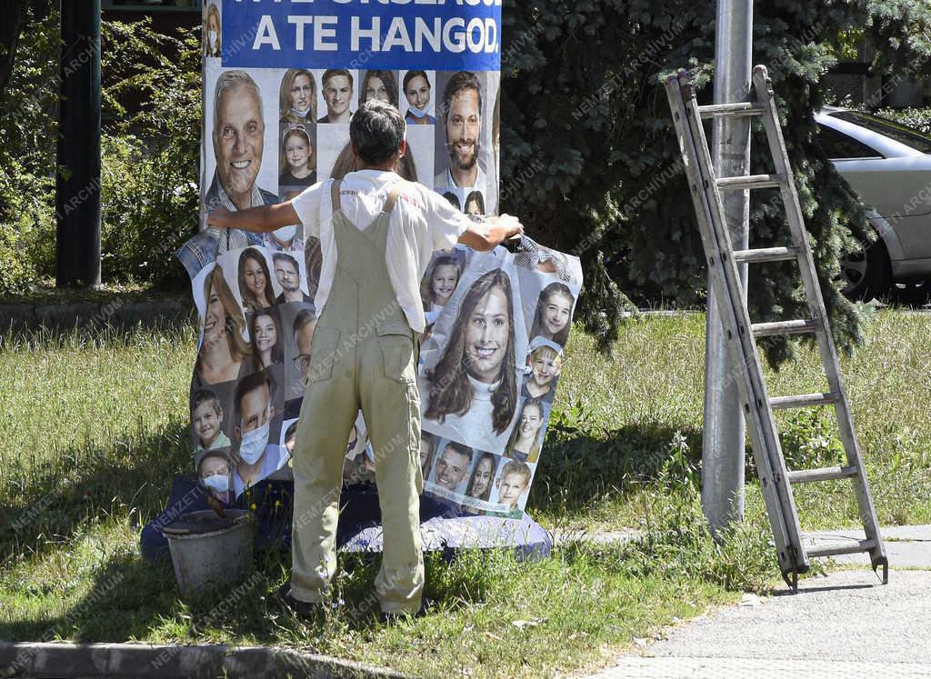 Városkép - Budapest - Plakátragasztó dolgozik a Füredi úti lakótelepen