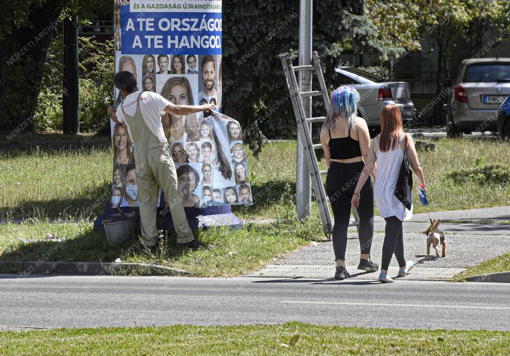 Városkép - Budapest - Plakátragasztó dolgozik a Füredi úti lakótelepen