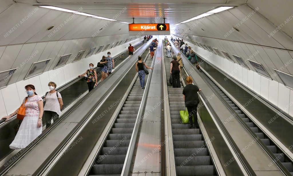 Koronavírus - Budapest - Védőmaszkos utasok a metró mozgólépcsőjén