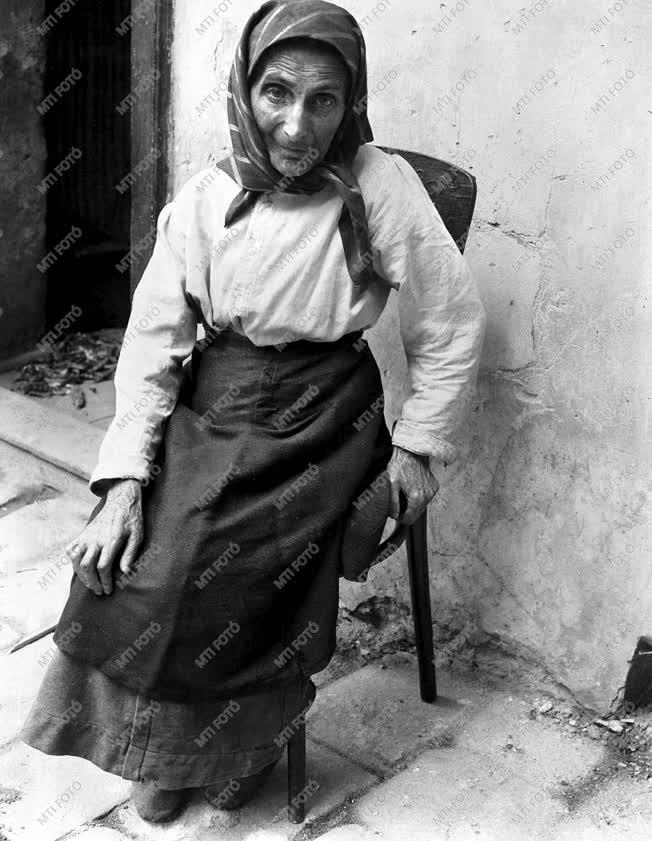 Szabadidő - Idős asszony ül háza előtt