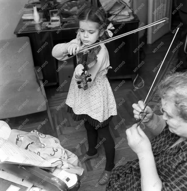 Városkép-életkép - Kislány a hegedűjén gyakorol