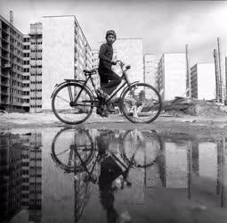 Városkép-életkép - Biciklis fiú a toronyházak mellett