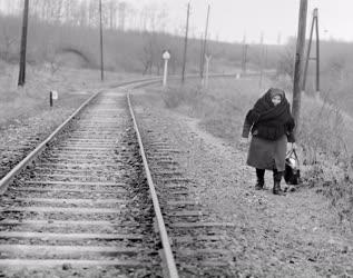Életkép - Idős asszony a sínek mellett