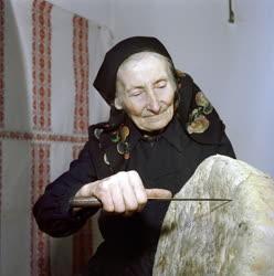 Életkép - Idős nő kenyeret szel